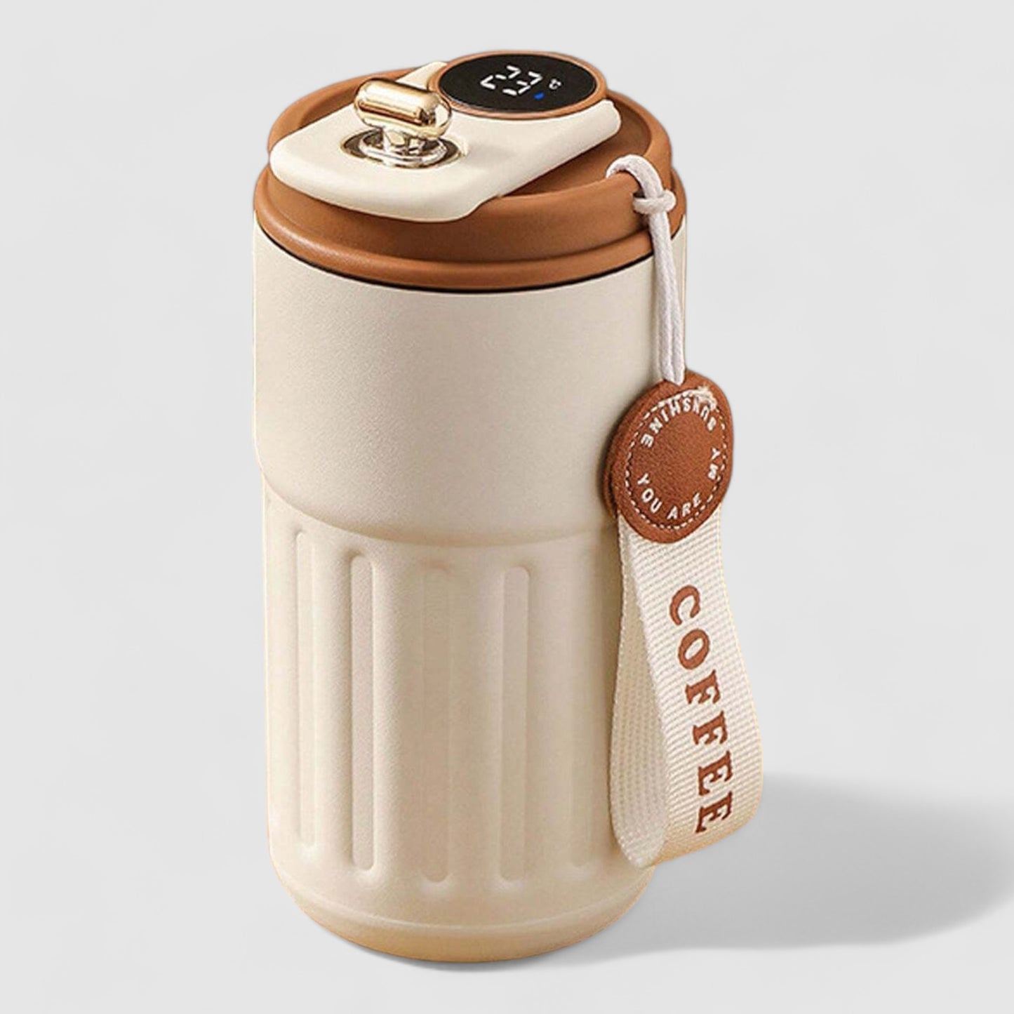 A beige insulated coffee mug with a belt attached to it, featuring a built-in LED display on the lid and a 'COFFEE' tag around the strap.