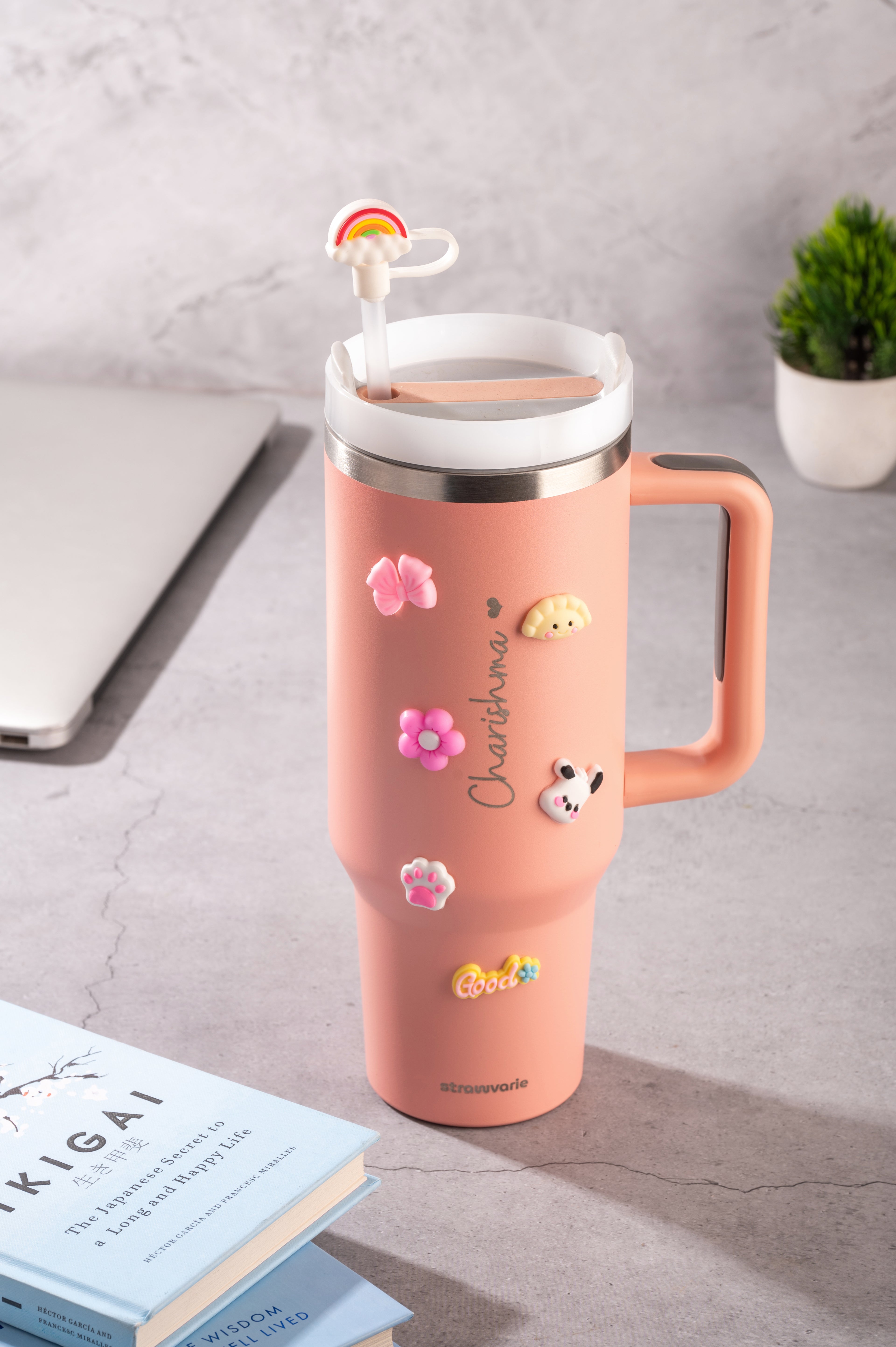a 1200 ml tumbler with charms and cute straw topper on it.