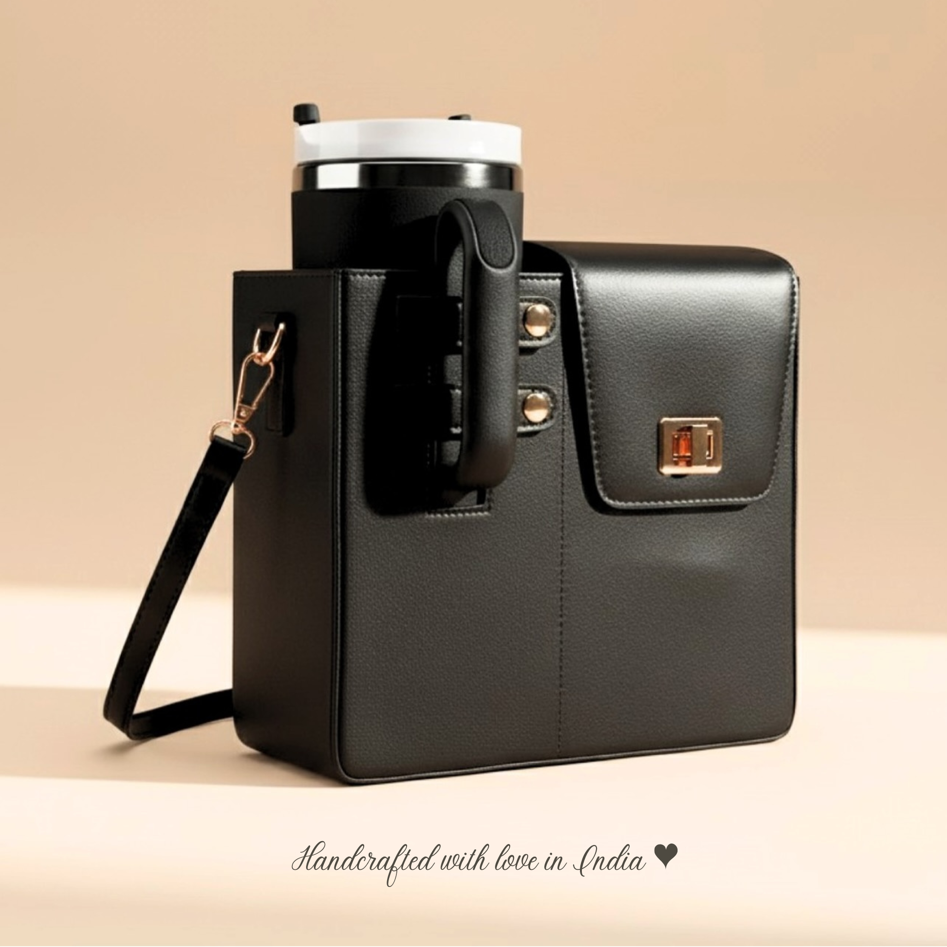 Black handbag with a tumbler, phone, and lip balm on a beige background